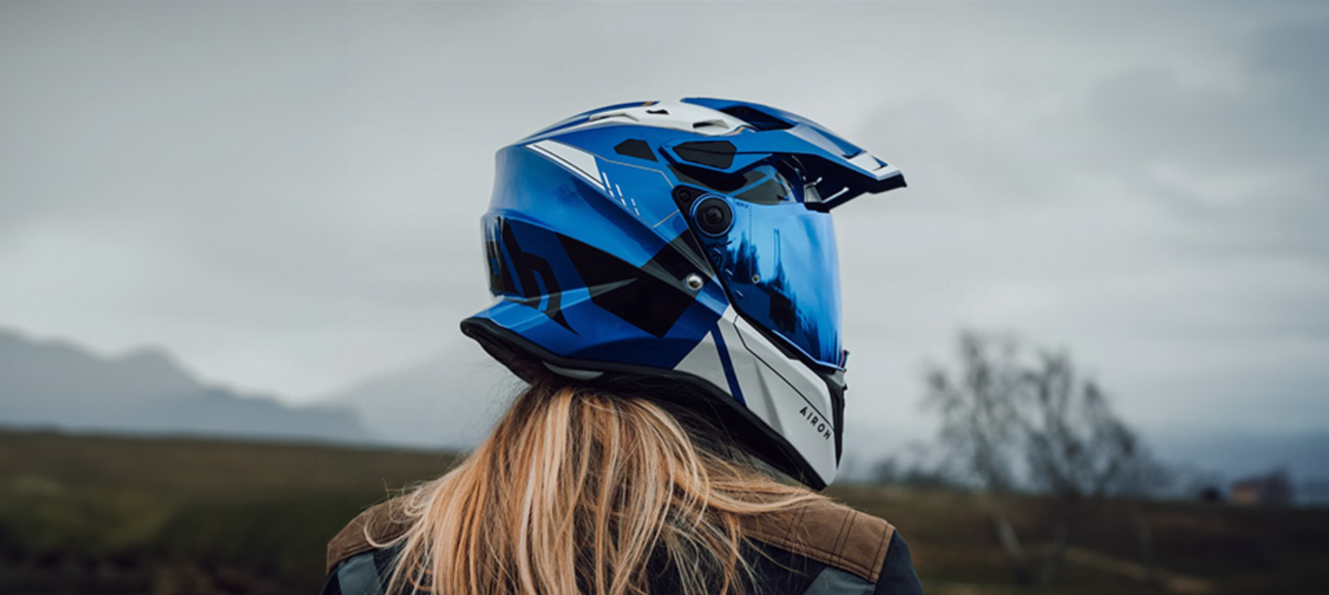 Back view of woman wearing helmet looking into distance.