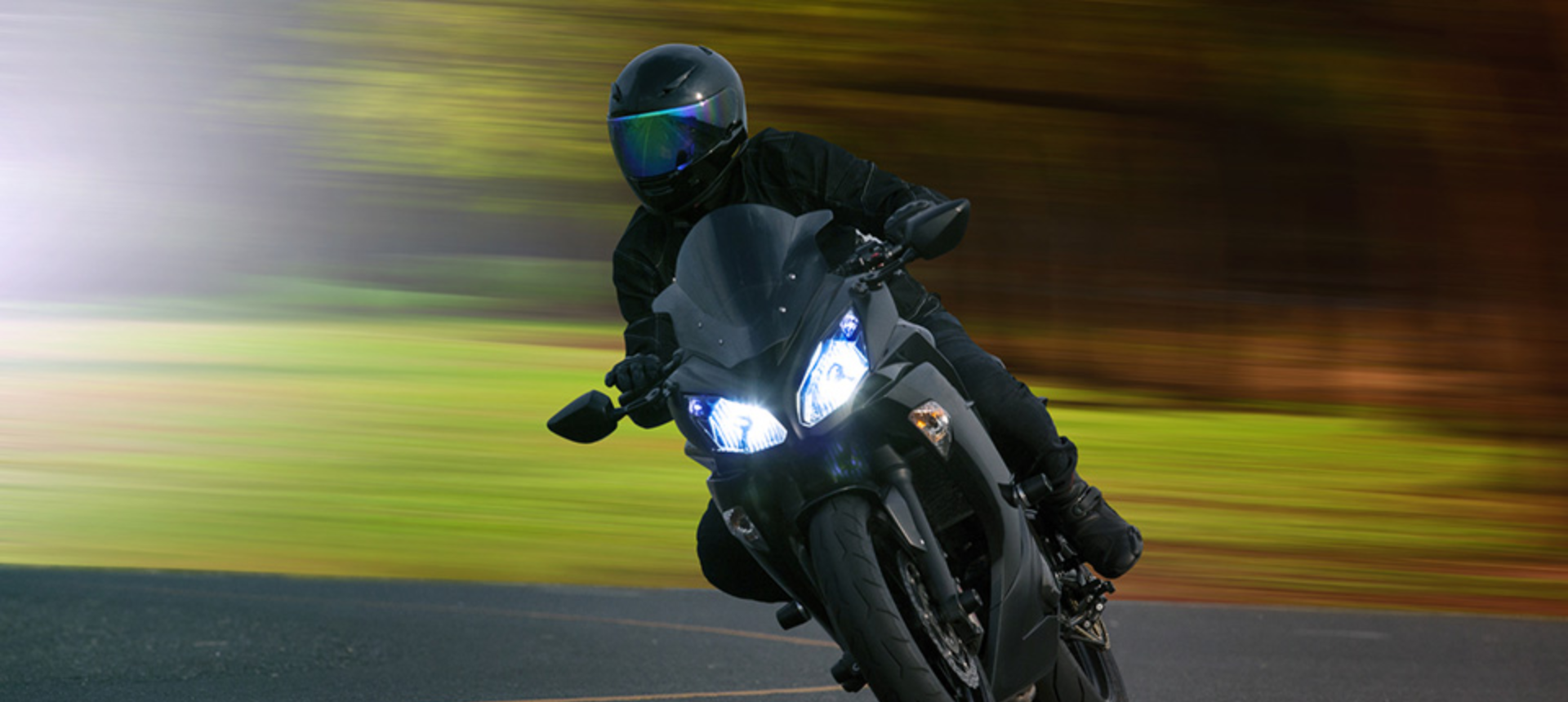 Person riding a sports motorcycle whilst wearing a full face helmet.