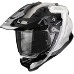 A full-face off-road motorcycle helmet in a glossy black and white color scheme, featuring a clear visor and visible 'SCORPION' branding on the lower front.