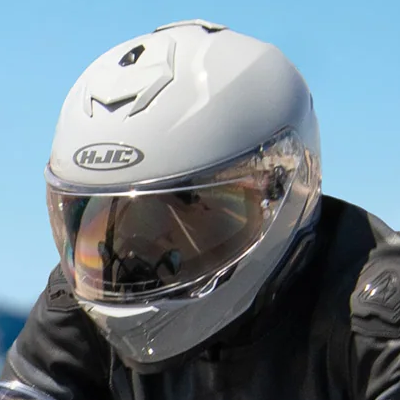 Person riding motorbike wearing full face helmet.
