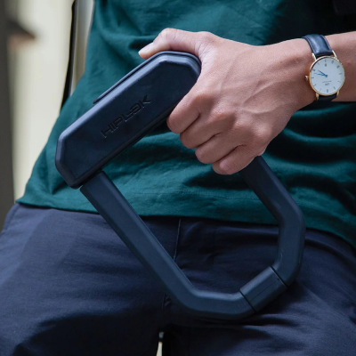 Person holding solid motorcycle lock in hand.
