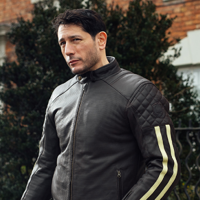 Man stood wearing leather motorcycle jacket.