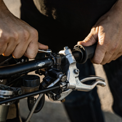 Man servicing motorbike with spanner.
