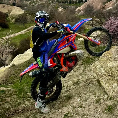 Motocross rider climbing rocks on bike.