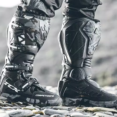 Close up of person wearing off road motorcycle boots.