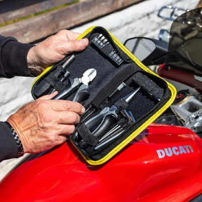 Biker with toolkit open on motorbike.