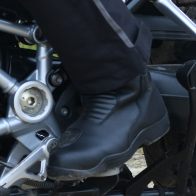 Close up of person riding motorbike whilst wearing touring motorcycle boots.